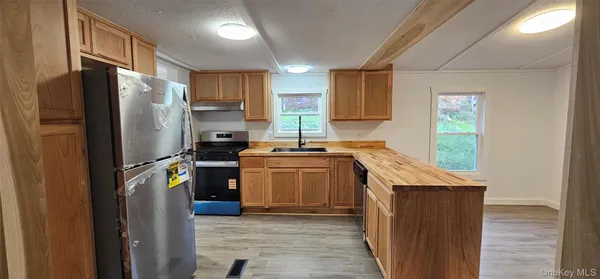 a kitchen with wooden floors and white cabinets