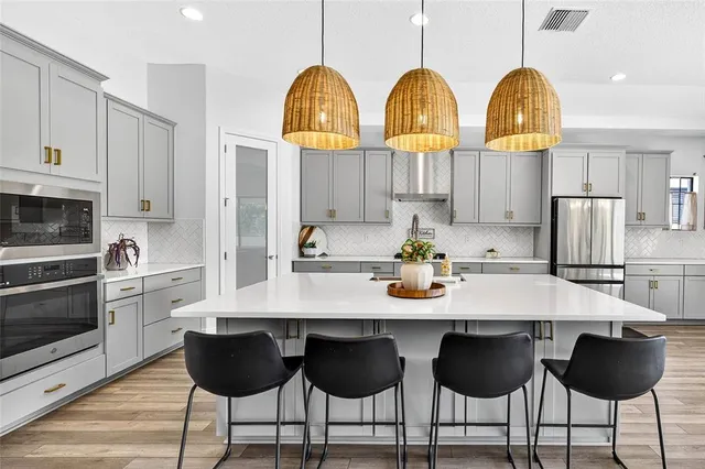 a kitchen with a refrigerator a sink and wooden floor