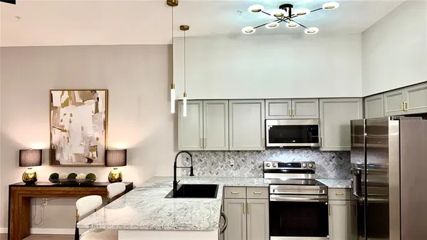 a kitchen with stainless steel appliances a stove microwave and sink