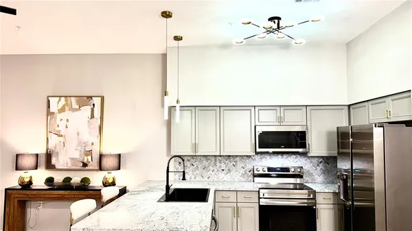 a kitchen with stainless steel appliances a stove a microwave and a refrigerator