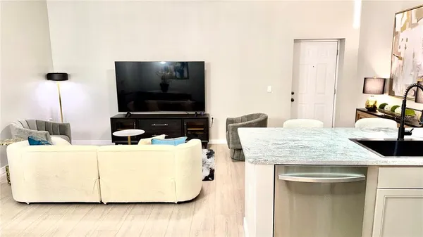 a living room with a sink and a flat screen tv