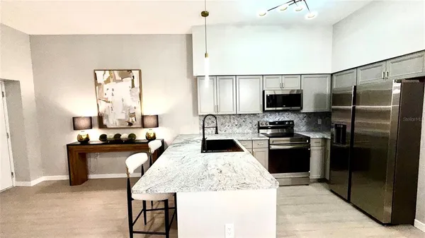 a kitchen with stainless steel appliances granite countertop a sink refrigerator and microwave