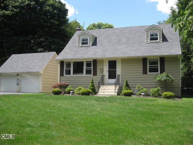 a front view of a house with a garden and yard