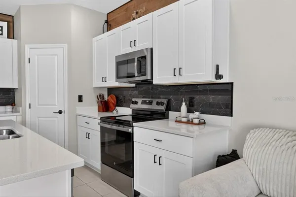 a kitchen with stainless steel appliances a sink a stove cabinets and a kitchen island