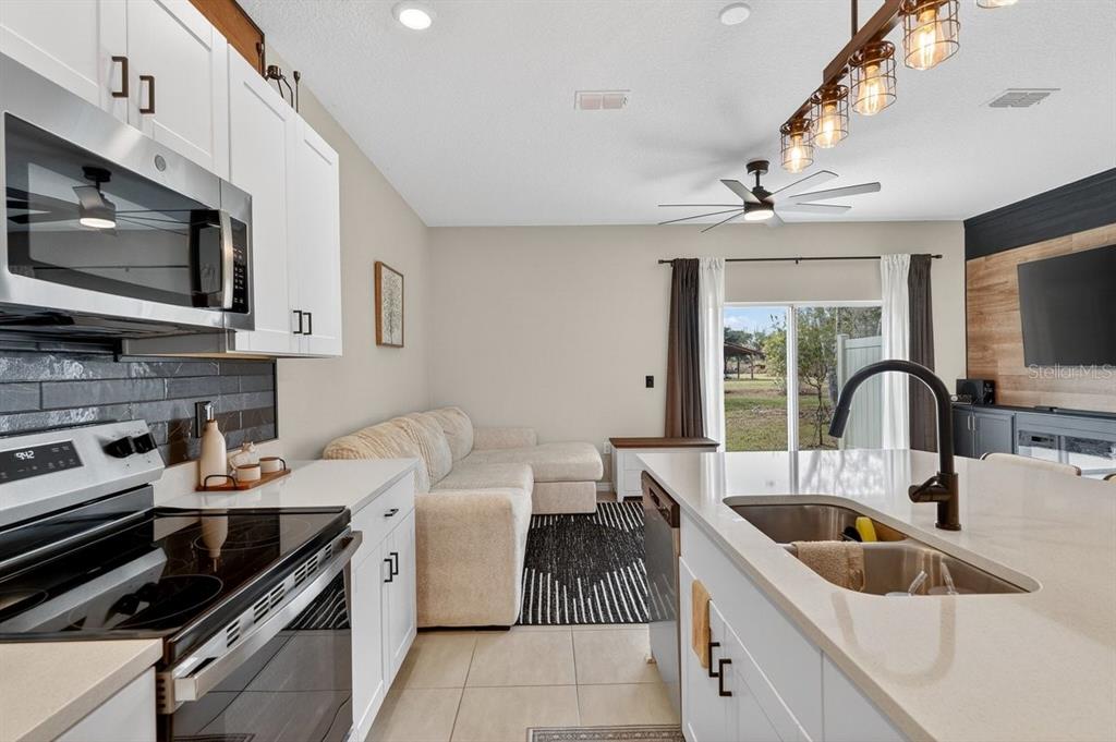 350 River Front Way Edgewater, FL 32141 - Photo 13 of 46 a kitchen with stainless steel appliances a sink a stove cabinets and a kitchen island
