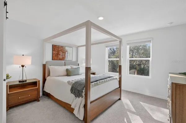 a bedroom with a bed and a painting on the wall