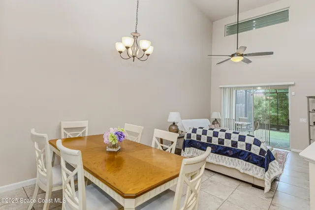 a view of a dining room with furniture a chandelier and a window
