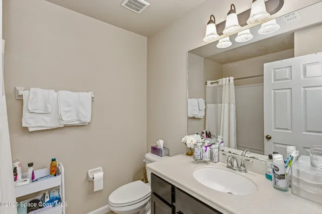 a bathroom with a sink vanity mirror and toilet