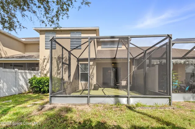 a view of a white house with a small yard and plants