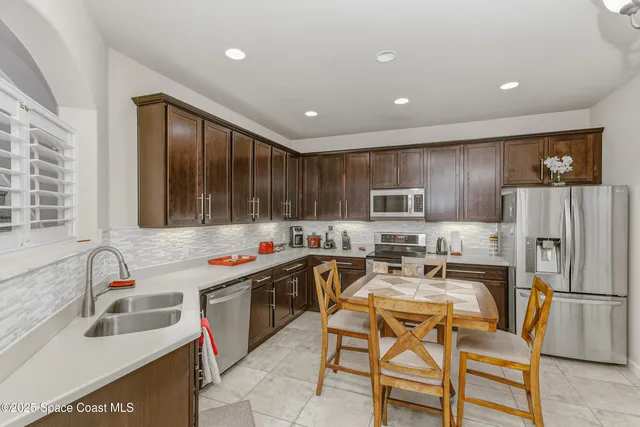 a kitchen with stainless steel appliances granite countertop a sink and a refrigerator