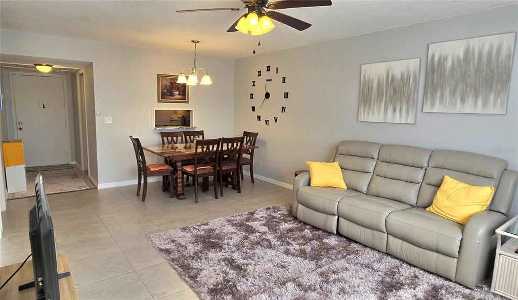 245 Center Road, Unit 104 Venice, FL 34285 - Photo 12 of 37 a living room with furniture a chandelier and a dining table