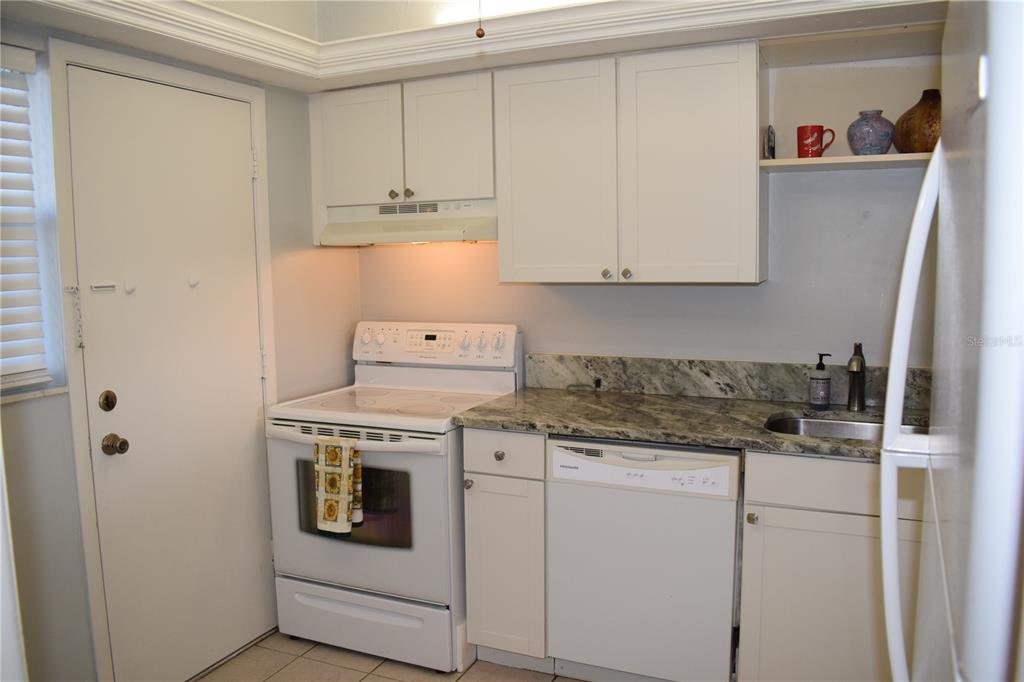 245 Center Road, Unit 104 Venice, FL 34285 - Photo 15 of 37 a kitchen with granite countertop white cabinets and white appliances