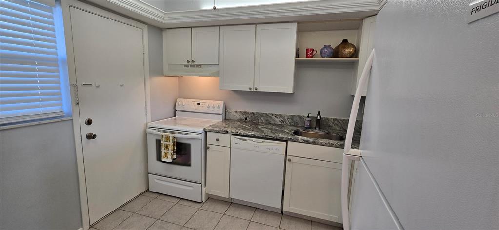 245 Center Road, Unit 104 Venice, FL 34285 - Photo 17 of 37 a kitchen with stainless steel appliances granite countertop a stove and a refrigerator