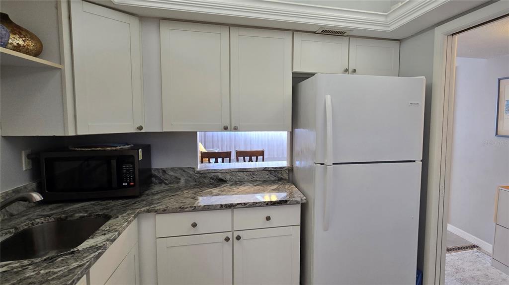 245 Center Road, Unit 104 Venice, FL 34285 - Photo 18 of 37 a white refrigerator freezer sitting inside of a kitchen