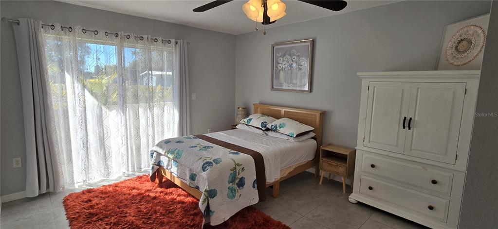 245 Center Road, Unit 104 Venice, FL 34285 - Photo 22 of 37 a bedroom with a bed and a chandelier