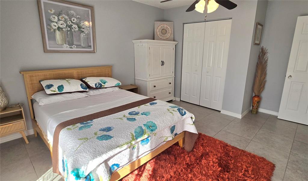 245 Center Road, Unit 104 Venice, FL 34285 - Photo 23 of 37 a bedroom with bed and painting on the wall