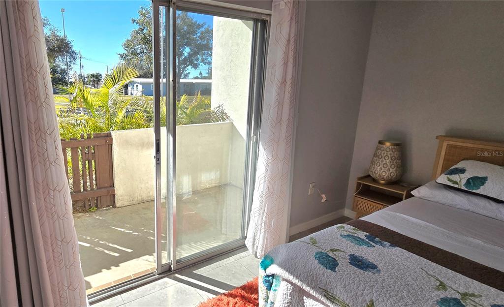 245 Center Road, Unit 104 Venice, FL 34285 - Photo 24 of 37 a bedroom with a bed and glass door