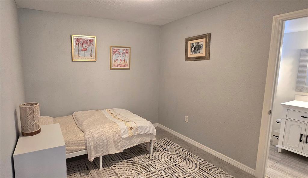245 Center Road, Unit 104 Venice, FL 34285 - Photo 27 of 37 a bedroom with a bed and wooden floor