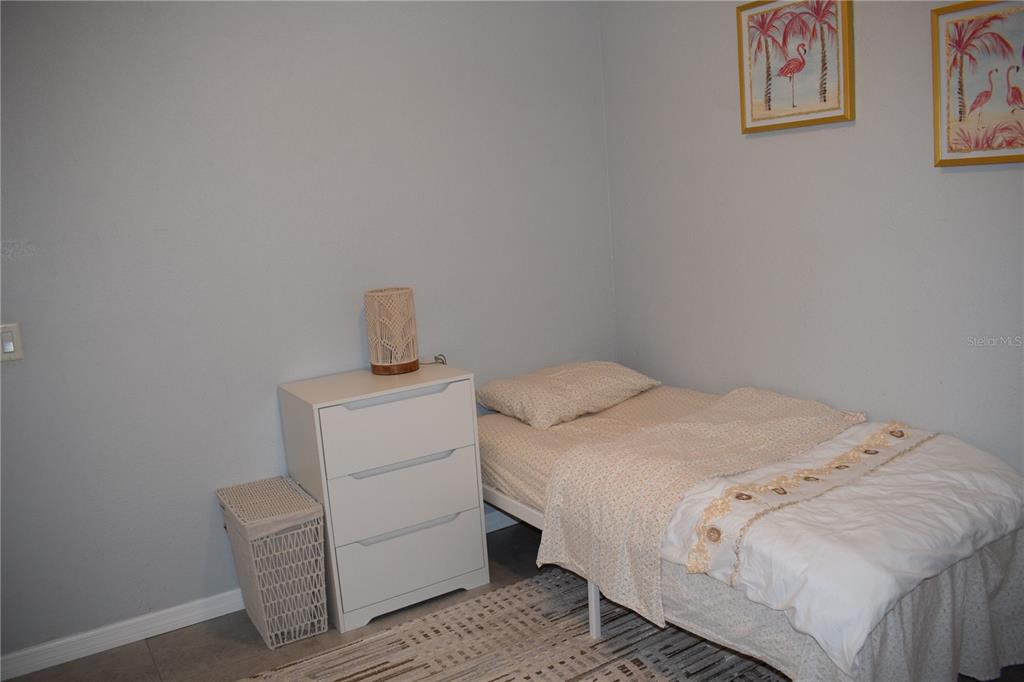 245 Center Road, Unit 104 Venice, FL 34285 - Photo 29 of 37 a bedroom with a bed and cabinet