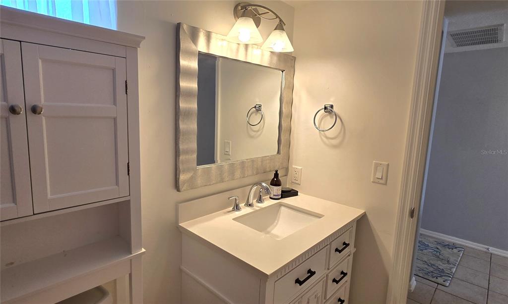 245 Center Road, Unit 104 Venice, FL 34285 - Photo 31 of 37 a bathroom with a sink and a mirror