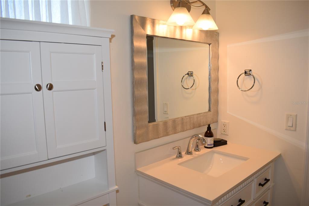 245 Center Road, Unit 104 Venice, FL 34285 - Photo 32 of 37 a bathroom with a sink vanity and a mirror