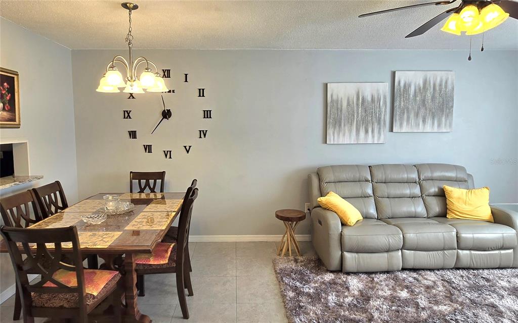 245 Center Road, Unit 104 Venice, FL 34285 - Photo 5 of 37 a living room with furniture and a chandelier