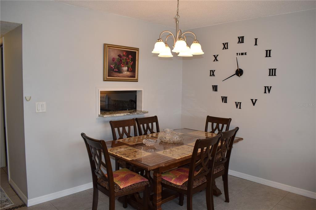 245 Center Road, Unit 104 Venice, FL 34285 - Photo 7 of 37 a view of a dining room with furniture a chandelier and wooden floor