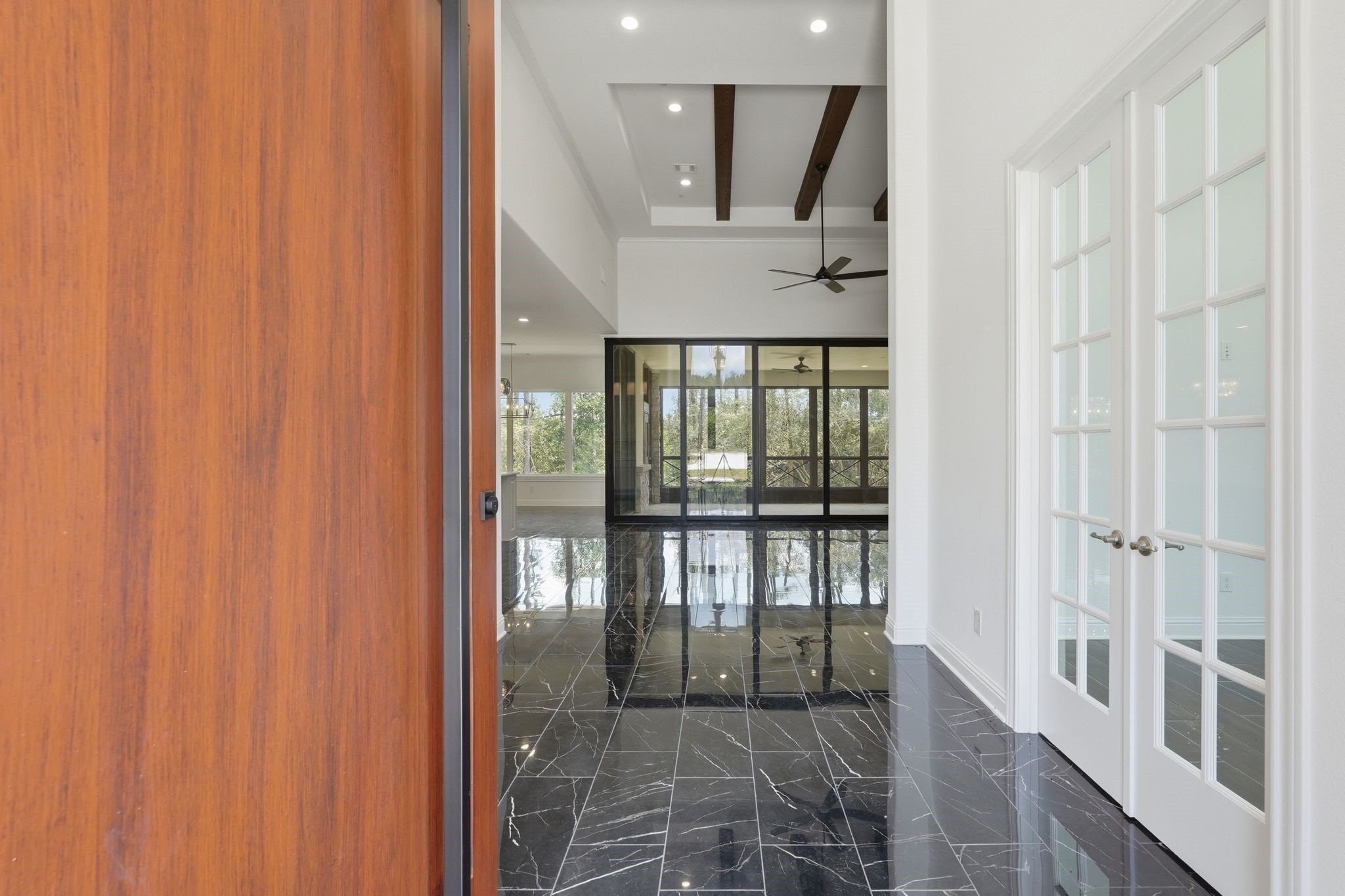 16081 Forest Mill Road Willis, TX 77378 - Photo 4 of 37 Impressive entry welcomes you with expansive sightlines, black marble tile, natural light and modern architectural details.
