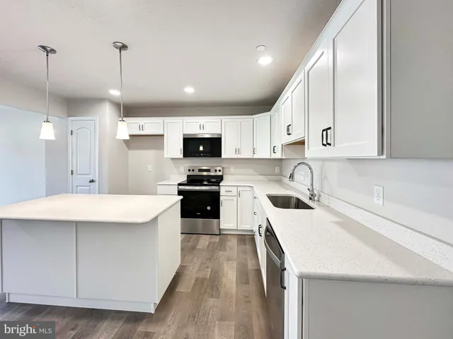 a kitchen with stainless steel appliances kitchen island granite countertop a sink stove and refrigerator