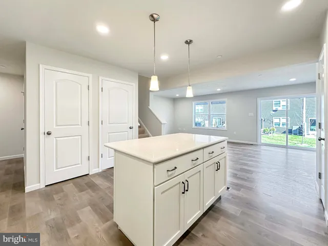 a kitchen with a stove and a wooden floor