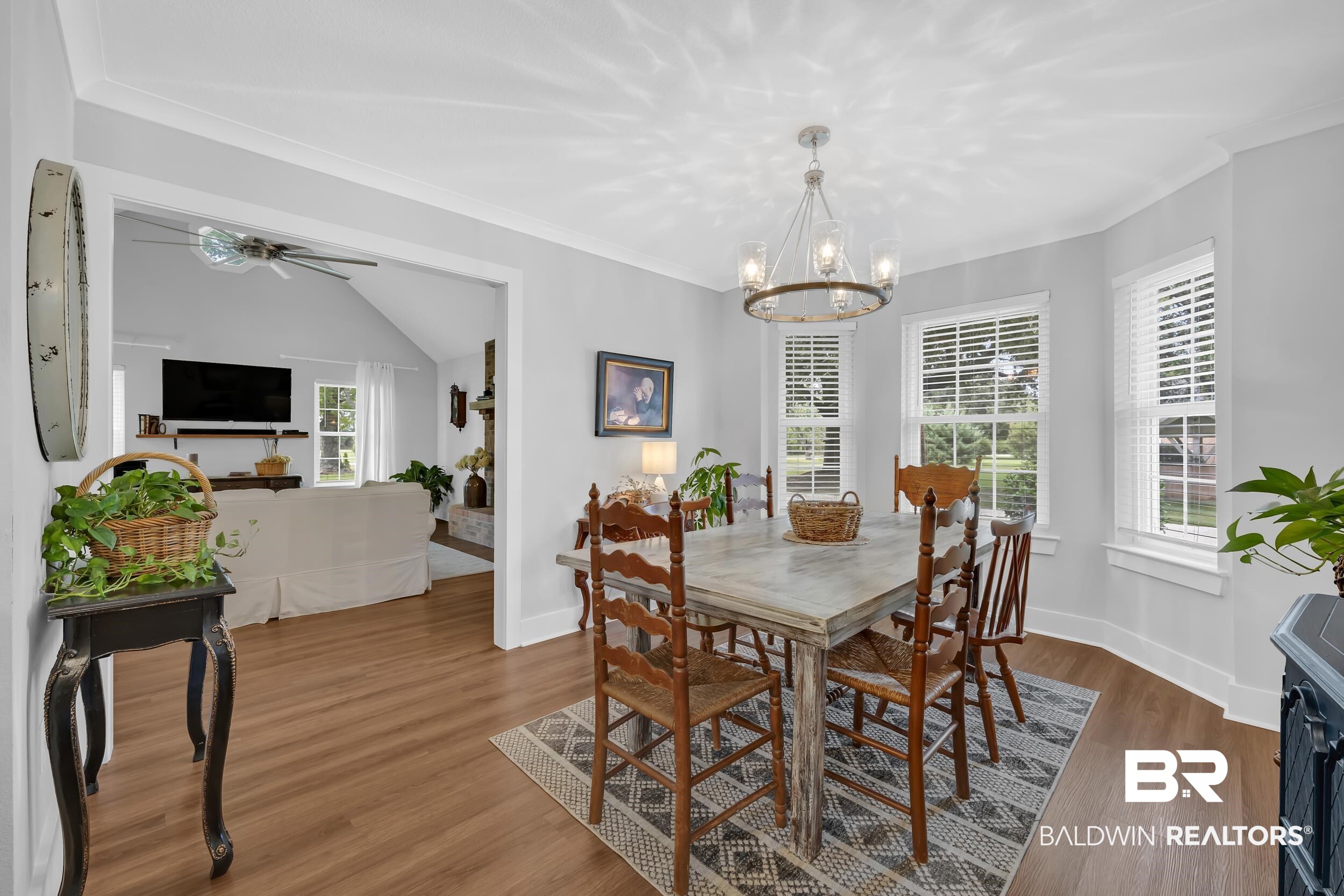 19090 Gunnison Road Fairhope, AL 36532 - Photo 11 of 42 Dining room with wood finished floors, ornamental molding, a chandelier, and ceiling fan