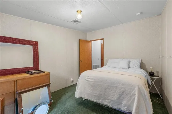 a bedroom with a bed and a lamp on table