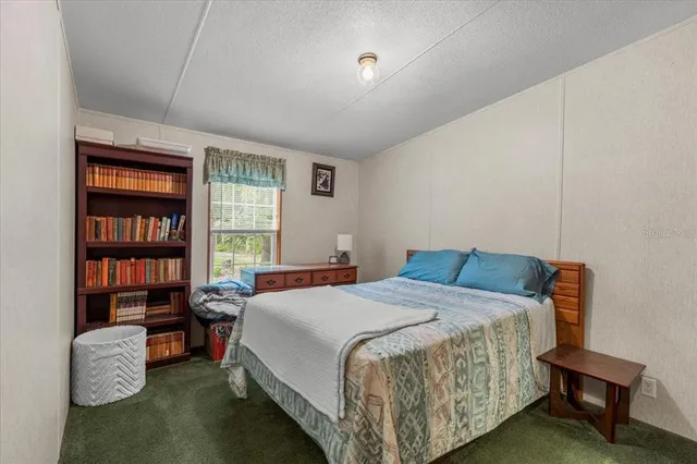 a bedroom with a bed and a book shelf