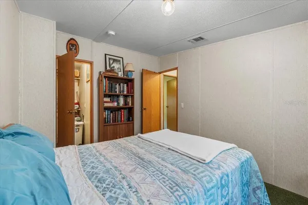 a bedroom with a large bed and a chandelier