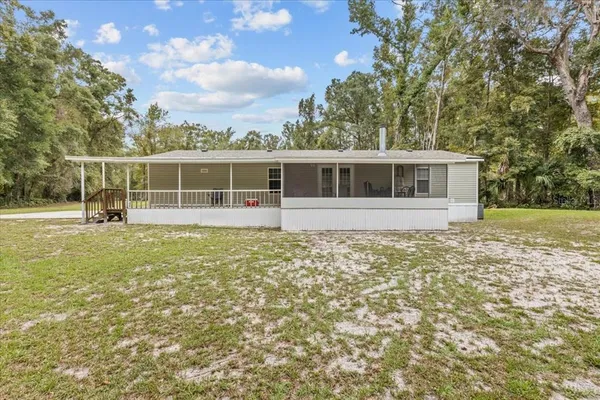 a view of a house with a garden and trees