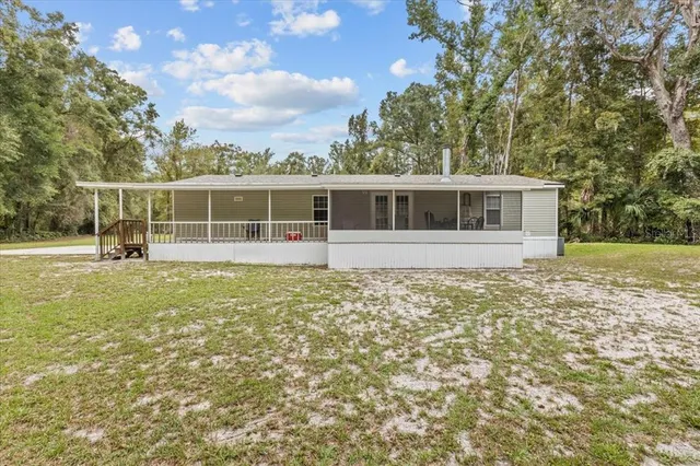 a view of a house with a garden and trees