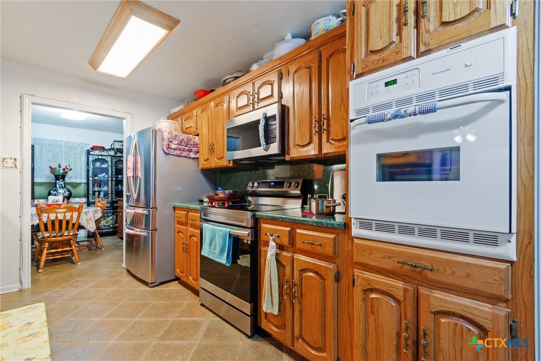 3037 Boys Ranch Road Kempner, TX 76539 - Photo 15 of 47 a kitchen with stainless steel appliances granite countertop a stove and cabinets