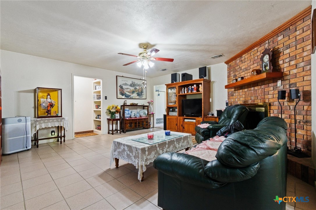 3037 Boys Ranch Road Kempner, TX 76539 - Photo 10 of 47 a living room with furniture a fireplace and a flat screen tv