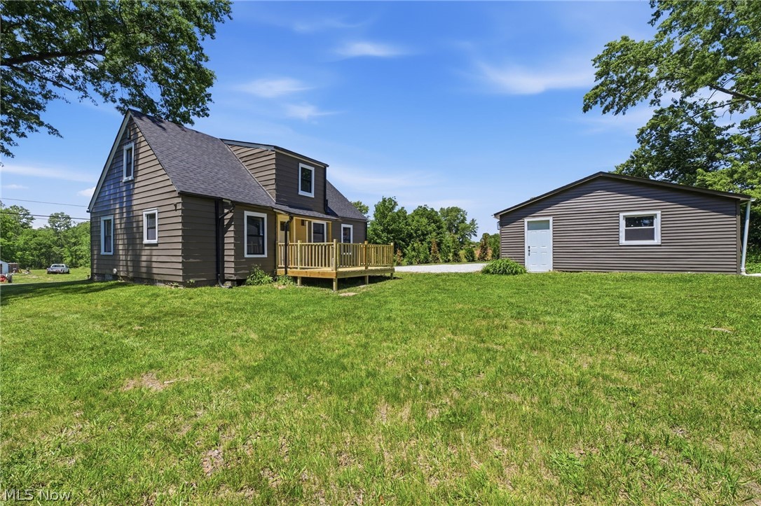 951 Bey Road Akron, OH 44312 - Photo 32 of 34 Spacious property featuring a main dwelling with a new wooden deck, a separate detached structure, brown horizontal siding, and a dark shingle roof