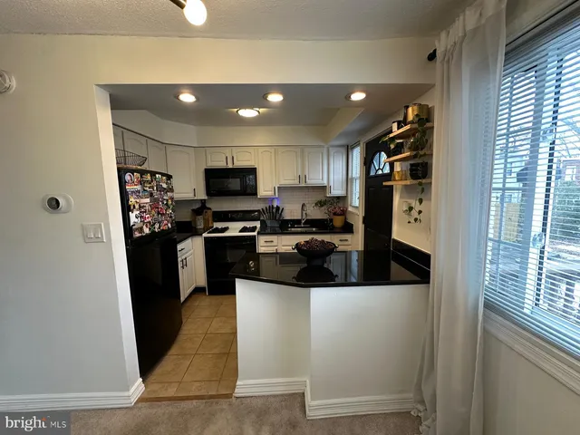 a kitchen with stainless steel appliances granite countertop a refrigerator a sink a stove top oven and a refrigerator