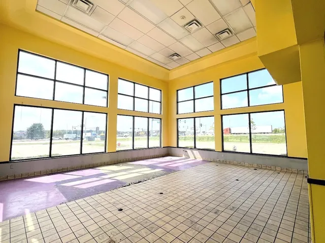 a view of a refrigerator in kitchen and an empty room