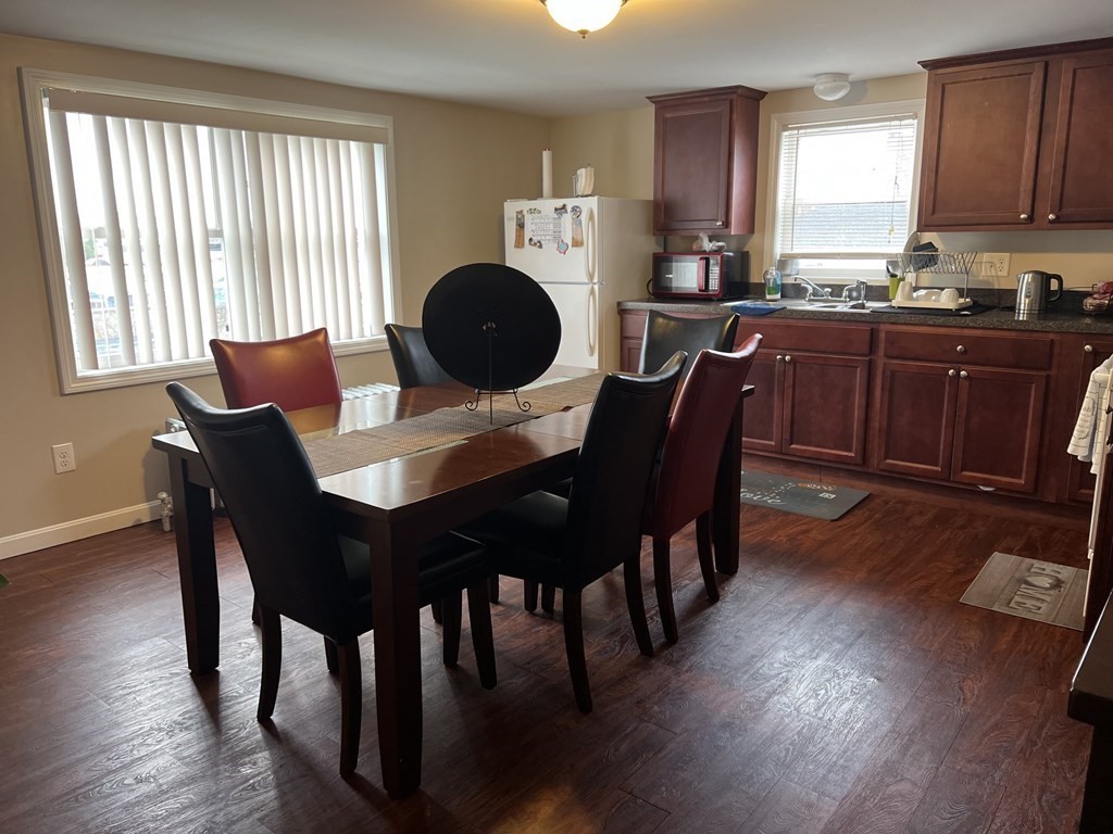 63 Brow Street Fall River, MA 02721 - Photo 13 of 35 a kitchen with granite countertop a dining table chairs and a wooden floor