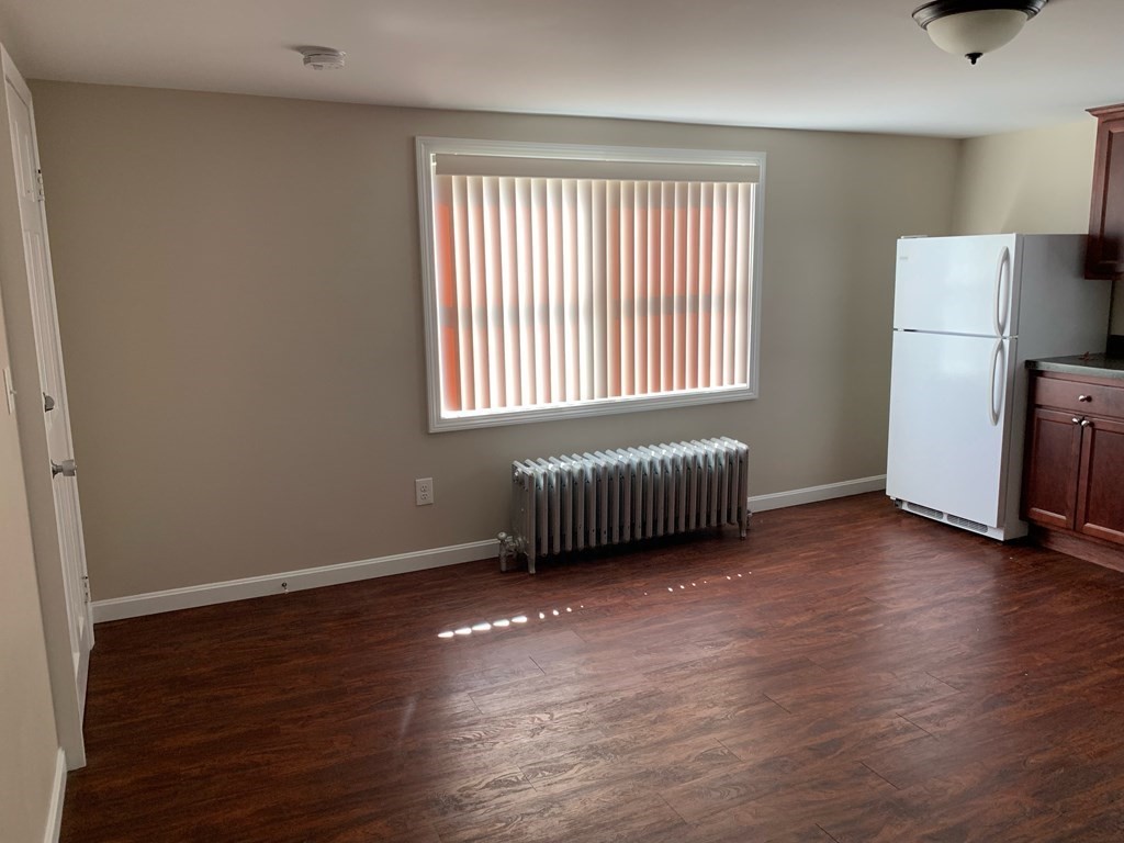 63 Brow Street Fall River, MA 02721 - Photo 15 of 35 a view of an empty room with a window and wooden floor