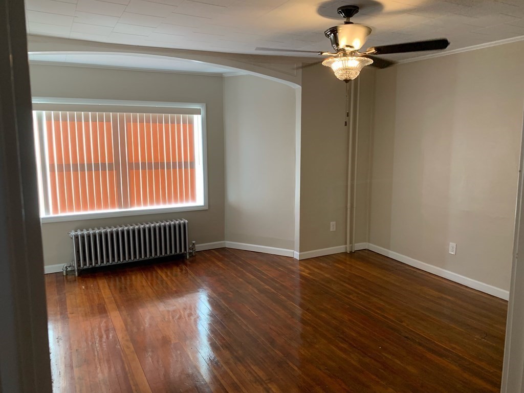 63 Brow Street Fall River, MA 02721 - Photo 23 of 35 an empty room with wooden floor chandelier fan and windows