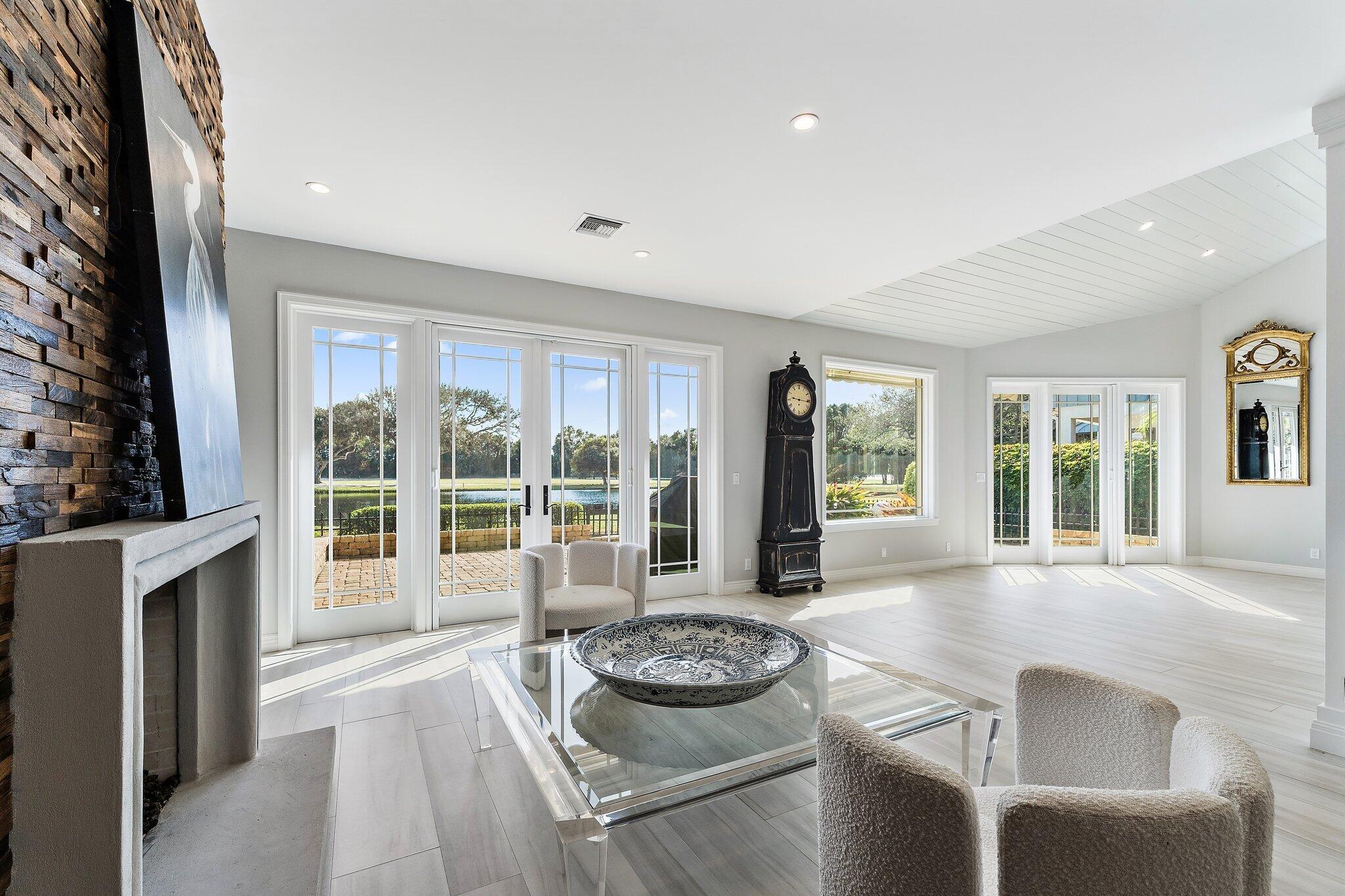 12092 Southeast Birkdale Run Jupiter, FL 33469 - Photo 15 of 53 a living room with fireplace furniture and floor to ceiling windows