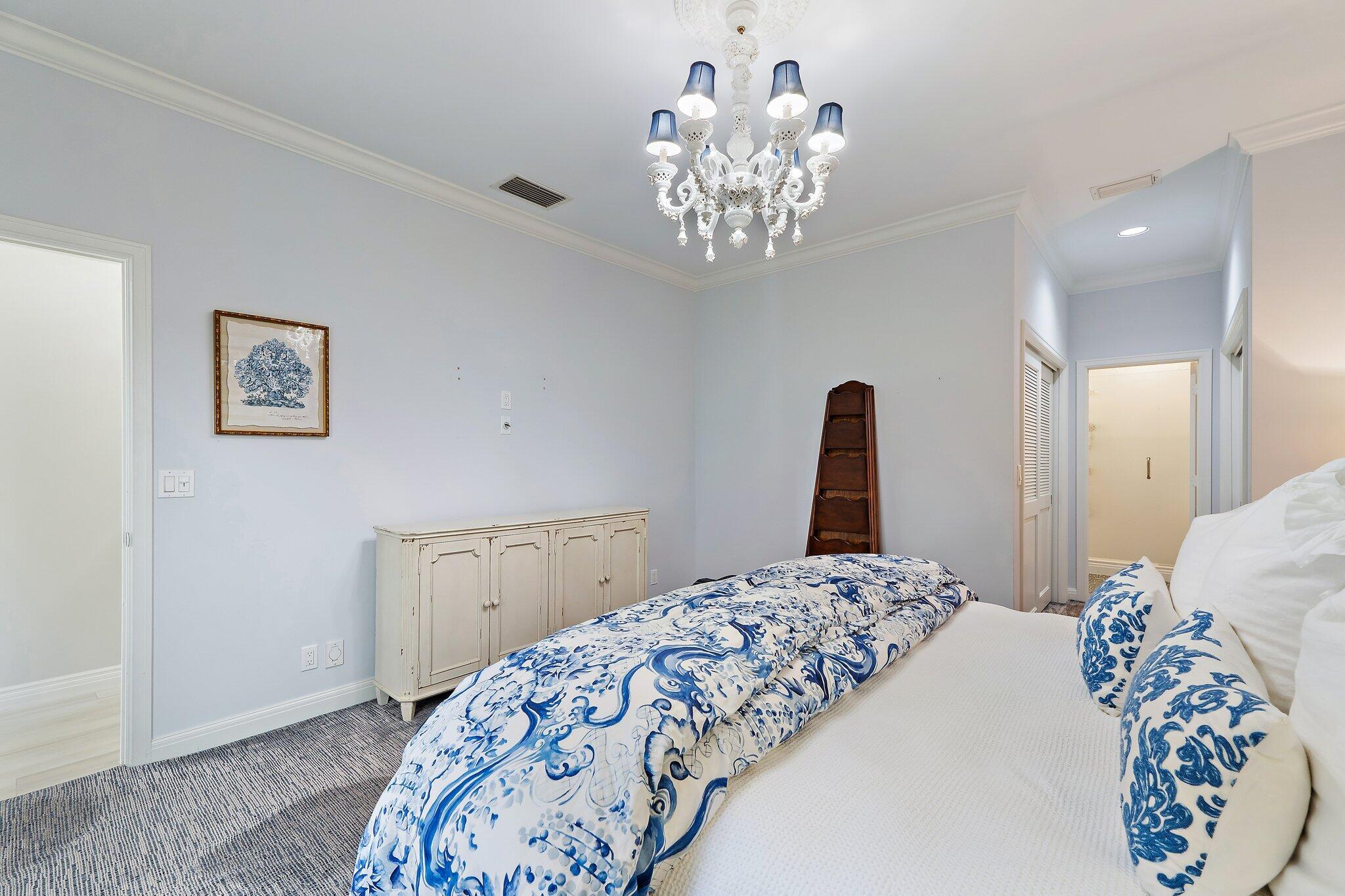 12092 Southeast Birkdale Run Jupiter, FL 33469 - Photo 33 of 53 a bedroom with a bed and a chandelier