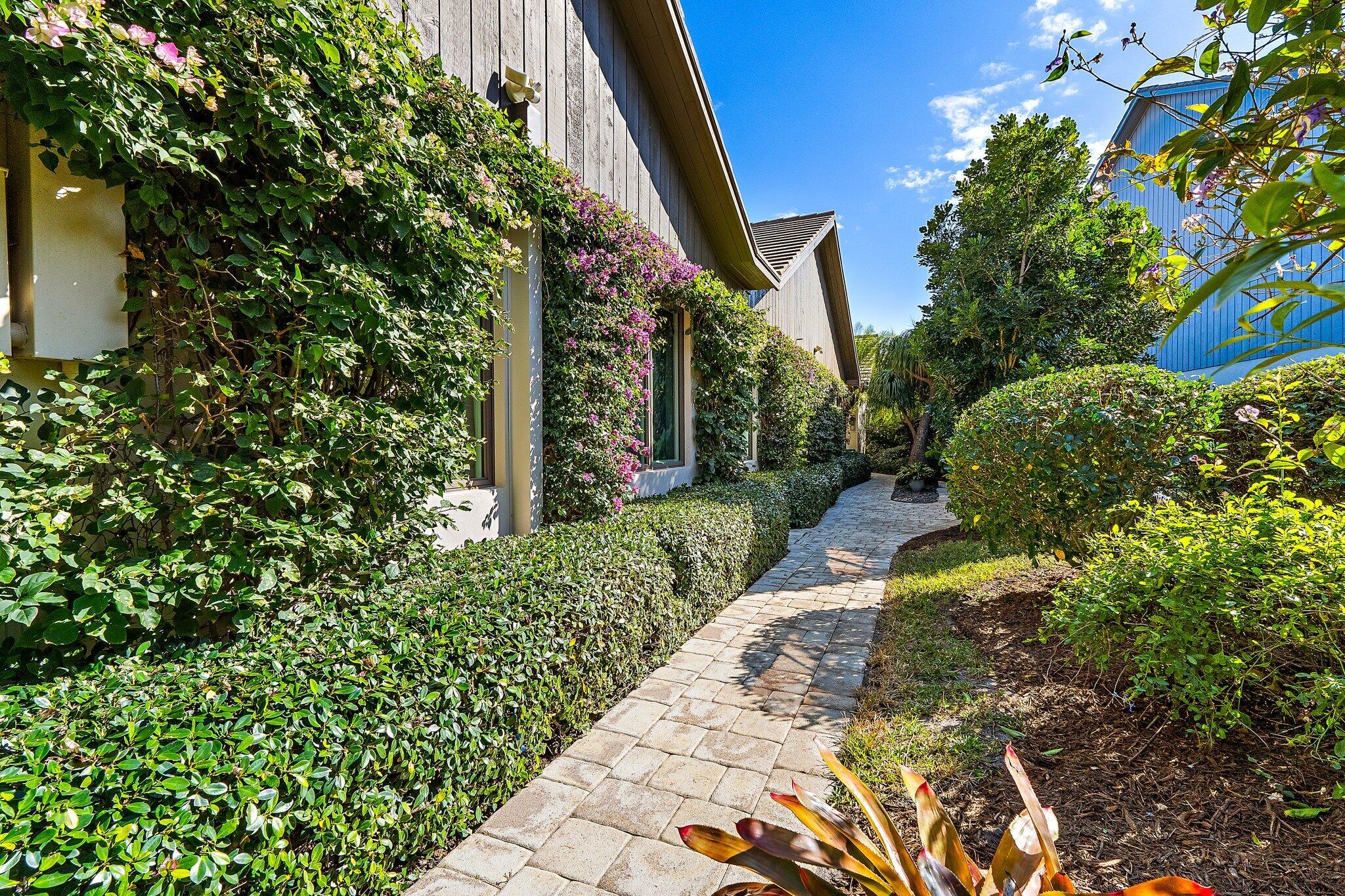 12092 Southeast Birkdale Run Jupiter, FL 33469 - Photo 4 of 53 a view of a pathway of flower plants