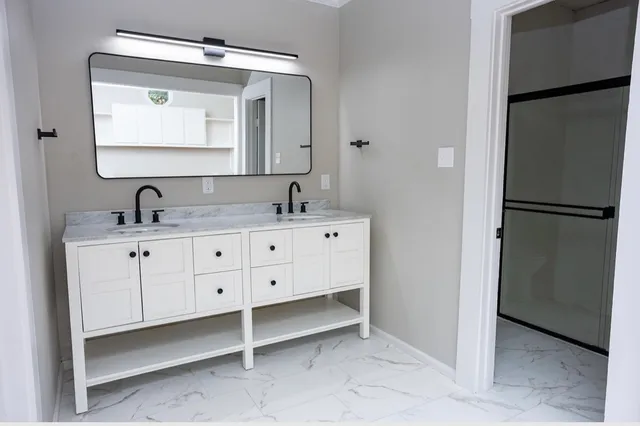 a bathroom with a double vanity sink and a mirror