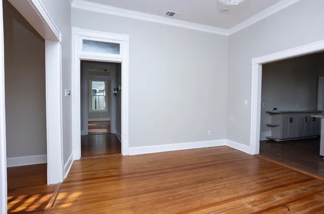 a view of empty room with wooden floor and cabinet