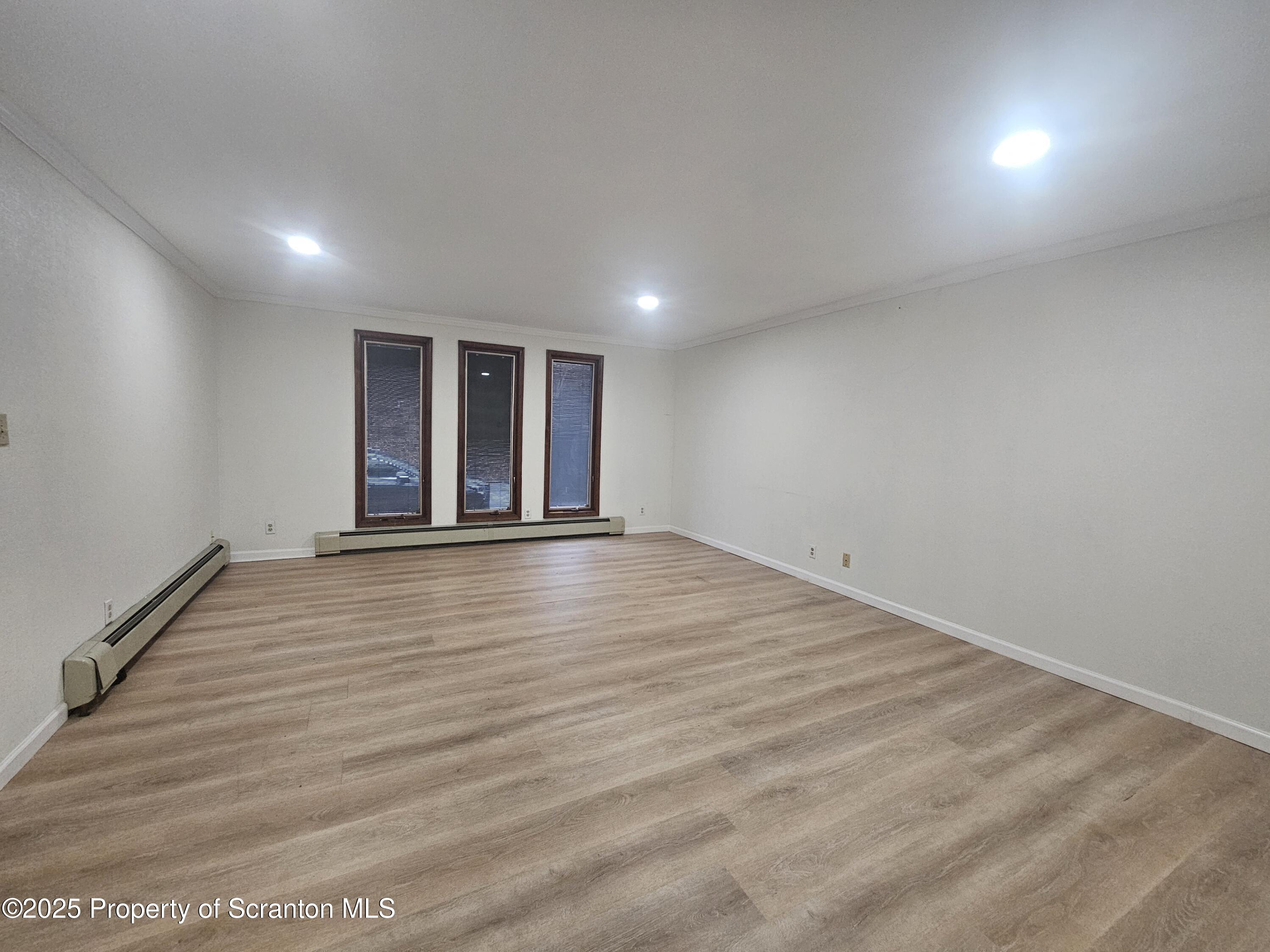 328 4th Street Blakely, PA 18447 - Photo 11 of 13 an empty room with wooden floor and windows